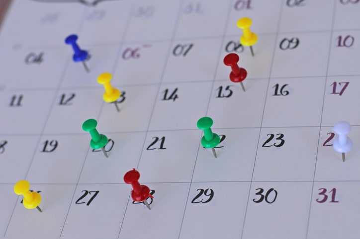 Colorful pins on calendar.