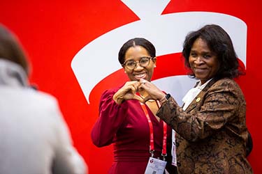 Scientific Sessions 2023 2 women making a heart with their hands.