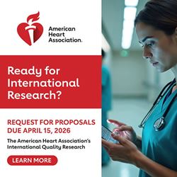 American Heart Association banner ad featuring the organization’s logo on the left, the headline ‘Ready for International Research?’ and text announcing a request for proposals due April 15, 2026. A ‘Learn More’ button appears below the text. On the right, a healthcare professional in scrubs reviews medical monitors in a hospital hallway.