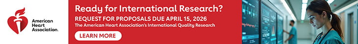 American Heart Association banner ad featuring the organization’s logo on the left, the headline ‘Ready for International Research?’ and text announcing a request for proposals due April 15, 2026. A ‘Learn More’ button appears below the text. On the right, a healthcare professional in scrubs reviews medical monitors in a hospital hallway.