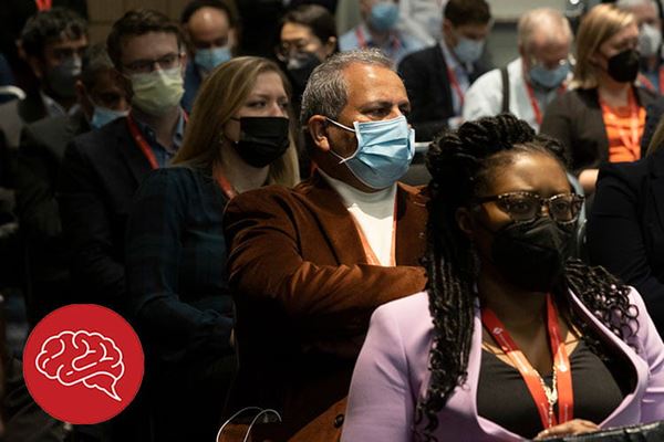 Photo of diverse ISC attendees listening to lecture, with ISC logo in lower left hand corner.