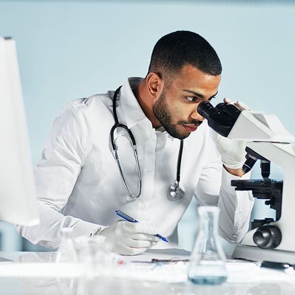 scientist in a laboratory looking through a microscope