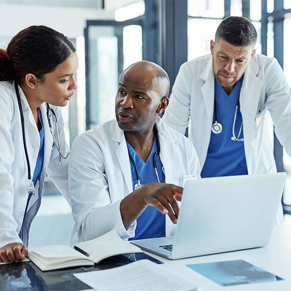 Group of medical professionals working on a laptop together