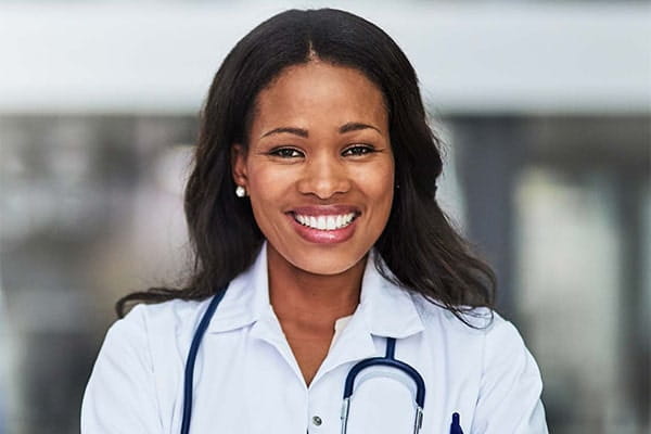 A young black women doctor smiling with a stethoscope