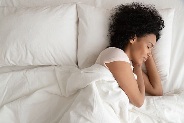 Young African American woman sleeping in a bed
