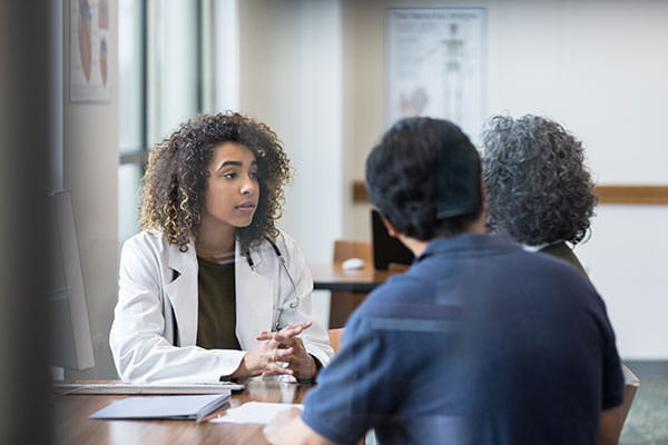 Mid-Adult Women Doctor listens carefully as mature patient speaks.