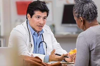 Male doctor consulting female patient