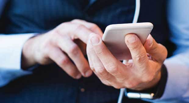 A man's hand holding a cellphone.