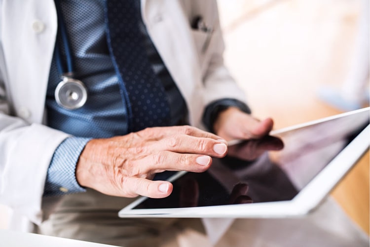 senior doctor with tablet working at the office