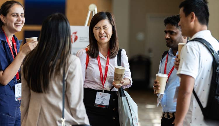 Some Early Career members share a laugh in the exhibits area of AHA's Hypertension 2022 meeting. 