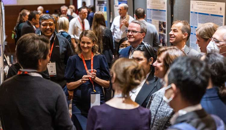 A group of Resuscitation Science Symposium attendees gather around a poster presentation in 2022.