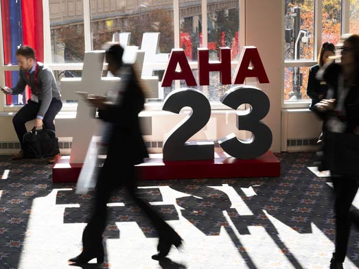 Scientific Sessions attendees walk past the #AHA23 sign