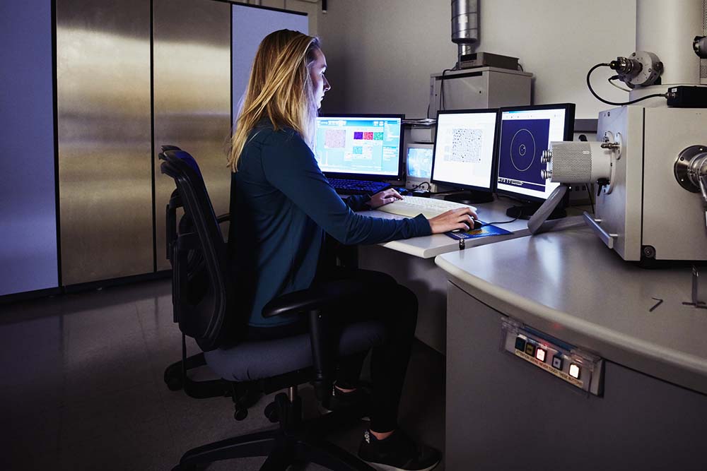 Female scientist in lab at desk on computer
