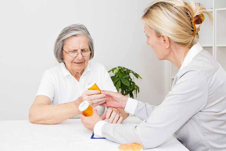 Mature nurse giving to senior woman Medication Instructions.