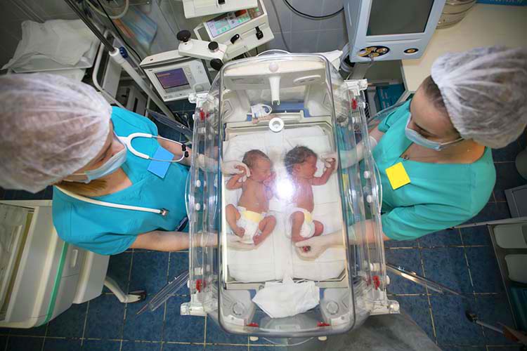 doctor stands with newborns in childrens hospital