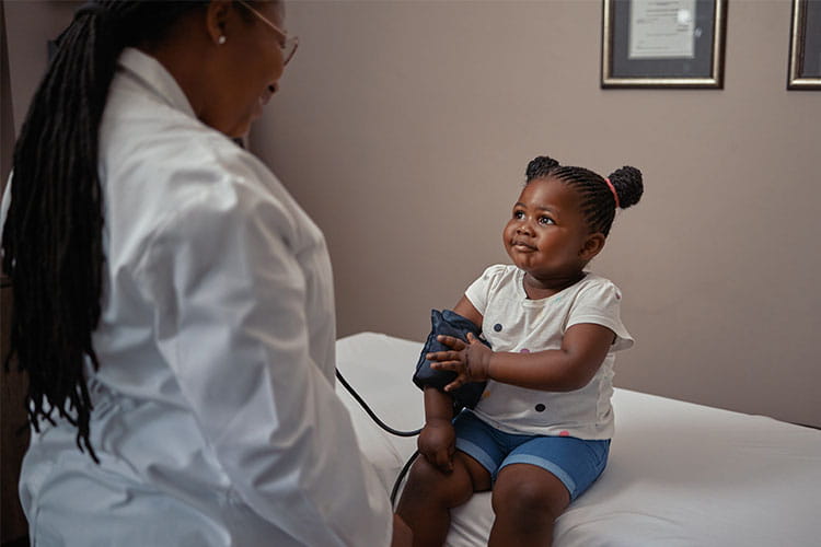 doctor checking little girls blood pressure