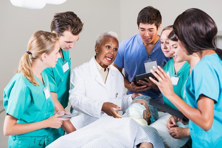 Doctor examining a patient with a group of medical students