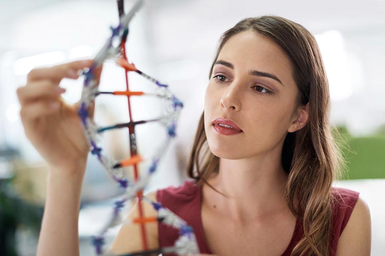 Young woman examining a model of DNA