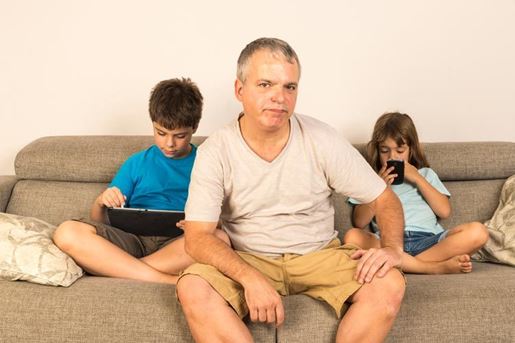 father and children sitting on the sofa