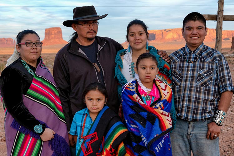 A group picture of a Navajo American Indians family outside