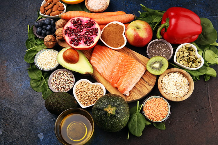 Healthy food clean eating selection: fish, fruit, vegetable, cereal, leaf vegetable on background.