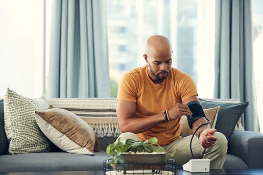 Young, black man taking blood pressure at home