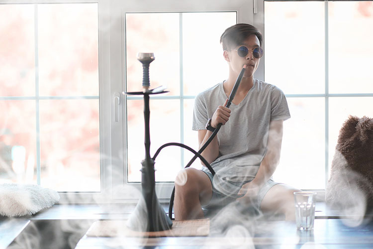 man in sunglasses smoking a hookah