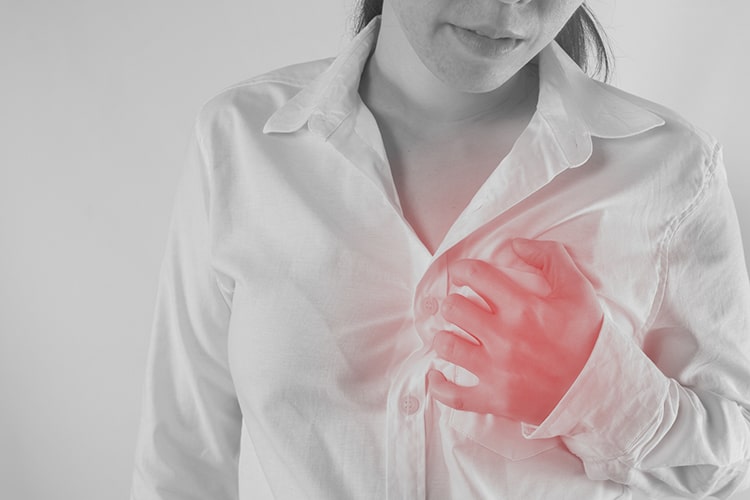 Midsection of Woman Suffering From Chest Pain Against White Background