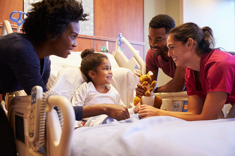 Pediatrician Visiting Parents and Child in Hospital Bed