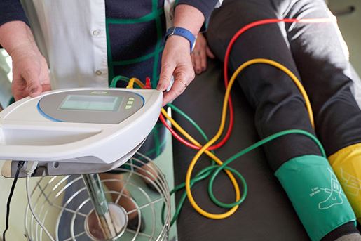 Peripheral artery disease measuring for patient ankle-brachial index (ABI) test limb ischemia. Medic hands working with device.