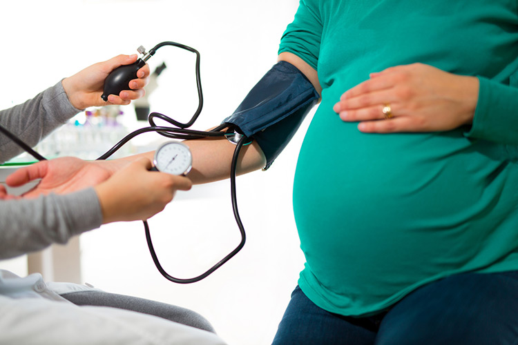 pregnant woman at doctors office having pressure measured