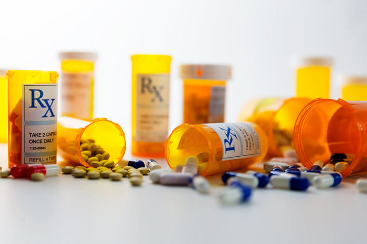 prescription bottles and pills on a counter
