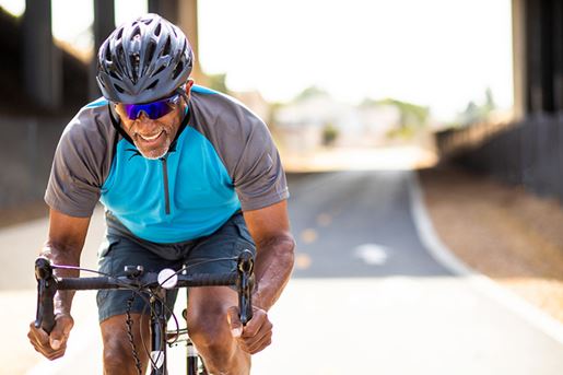 senior black man racing on a road bike