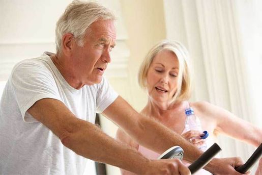 senior couple on exercise bike