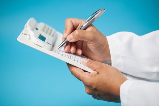 doctor writing on a clipboard
