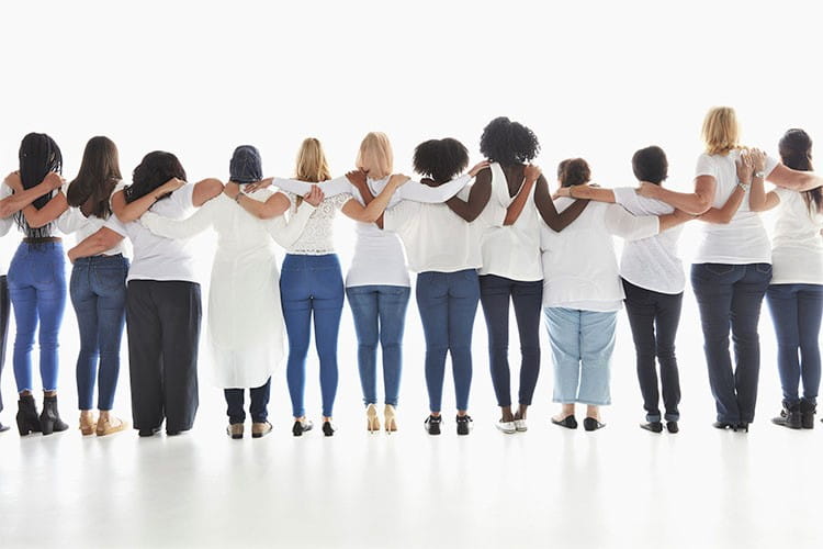 diverse women standing in row hugging