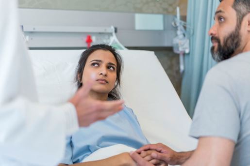 doctor explaining to a couple in hospital ward