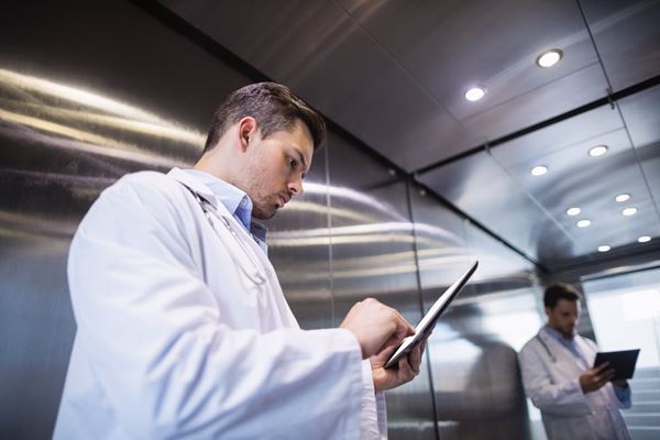 Doctor using a digital tablet in the corridor