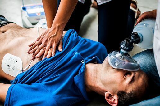 People assisting an unconscious man with cardiopulmonary resuscitation.