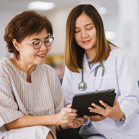 Woman patient sitting with doctor reviewing her charts