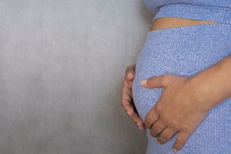 Pregnant women holding her belly with her hands