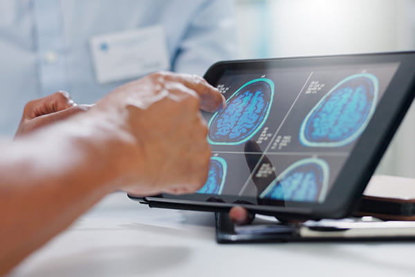 hands touching brain monitor display