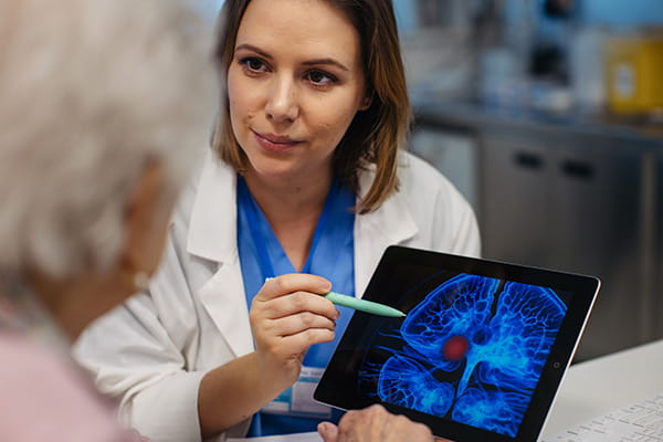 Female doctor explaining results of MRI Scan of brain to senior patient 