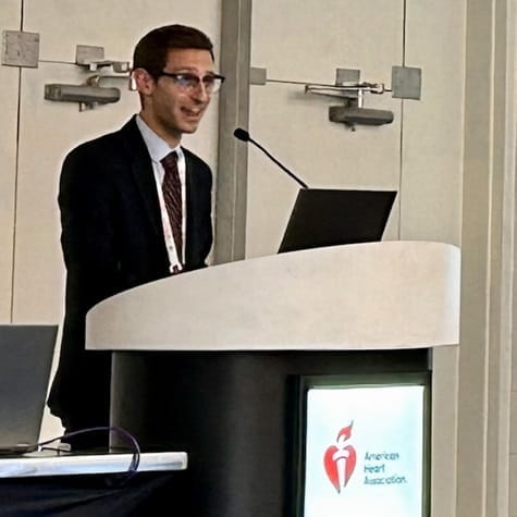 Abraham Bayer, PhD, speaking from a podium with the American Heart Association logo on it
