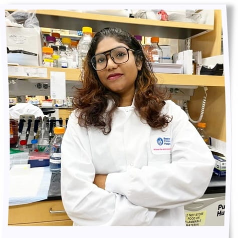Woman in a white lab coat, standing in a research laboratory