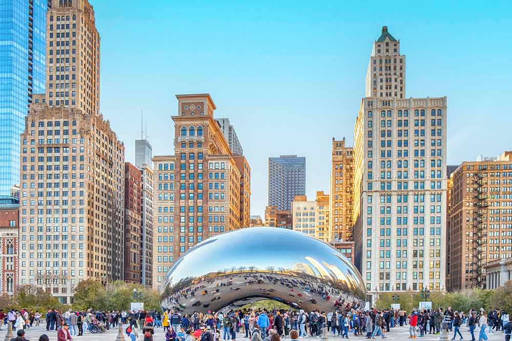 Crowds gather around the "Cloud Gate" sculpture at AT&T Plaza in Millenium Park, Chicago, Illinois.