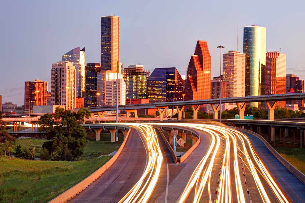 The skyscrapers of downtown Houston, Texas glow in the evening sun as commuters make their way home.