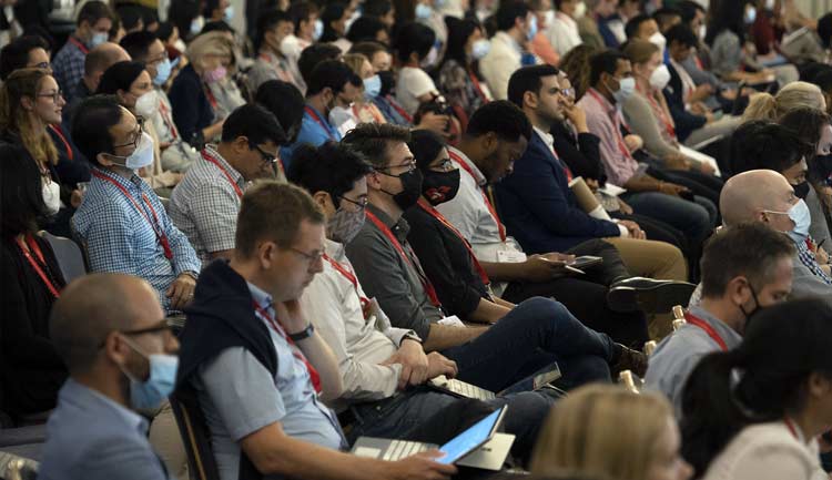 BCVS 2022 attendees are shown listening and taking notes during a presentation.