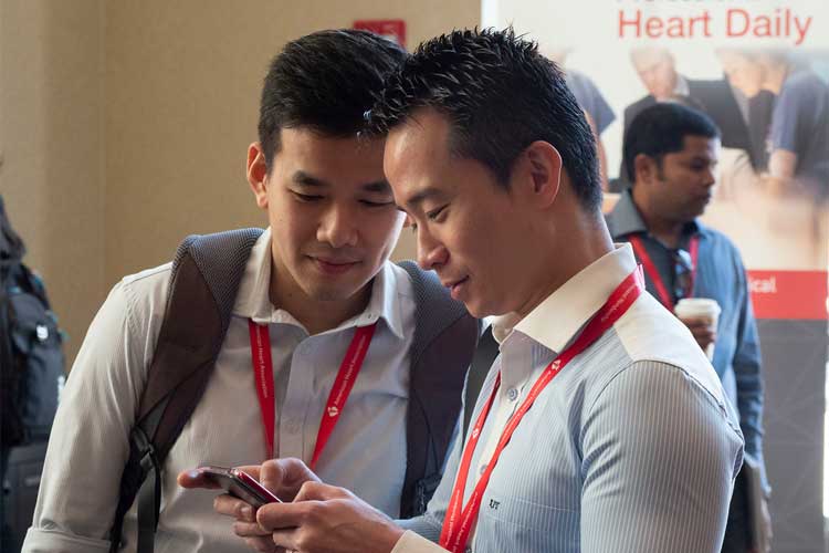 Two BCVS attendees checking the next session on a mobile device.