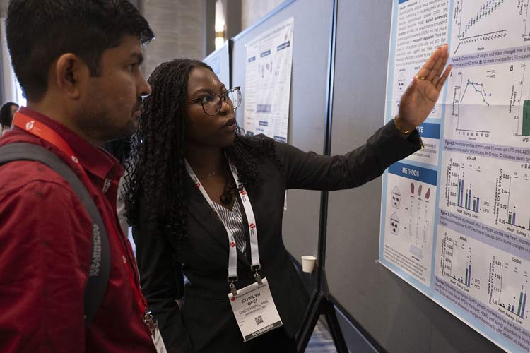 Two attendees explore a poster presentation during #BCVS25.